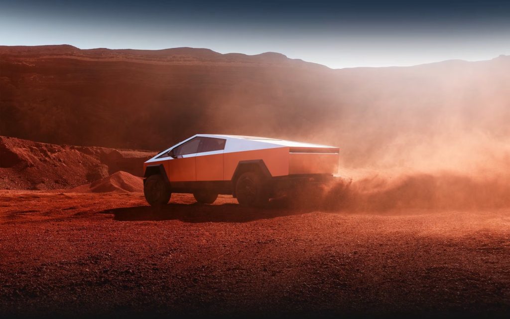 Tesla Cybertruck jadąca po pustyni podczas zachodu słońca